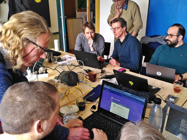 Tijdens de Linux020 Inloop, het kleine lokaaltje is propvol. Mensen buigen over een laptop om adviezen te geven. Tijdens de Linux020 Inloop, het kleine lokaaltje is propvol. Mensen buigen over een laptop om adviezen te geven.